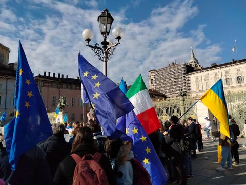 Menschen bei einer Demonstration in Italien mit Europaflaggen und Länderflaggen