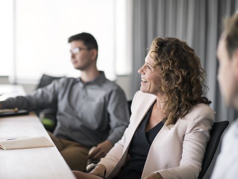 Happy businesswoman sitting in office meeting