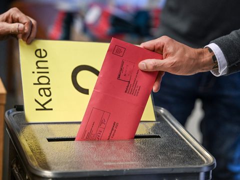 Mann bei der Stimmabgabe an einer Wahlurne