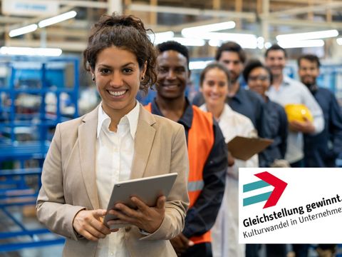 Das Bild zeigt eine Frau mit ihrem Team in einer Lagerhalle stehend, das Logo von Gleichstellung gewinnt rechts unten im Bild