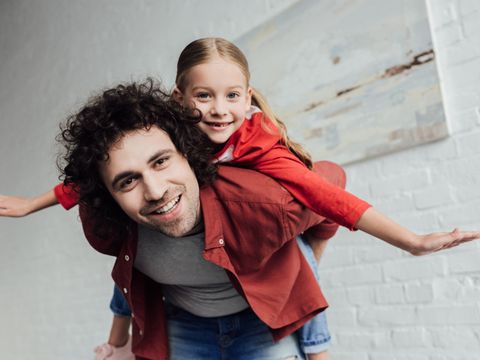 Vater mit Kind huckepack