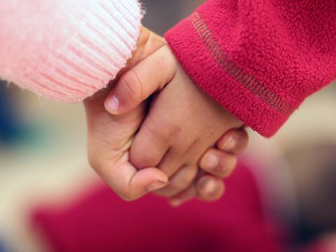 zwei Kinderhände halten einander