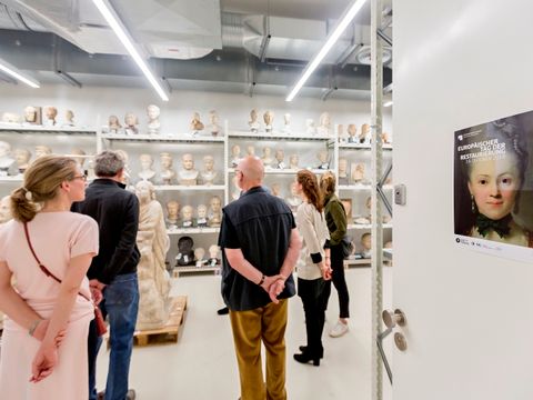 Besucher einer Führung stehen im Skulturendepot der Antikensammlung