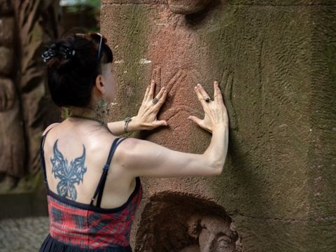 Mit den Händen am Denkmal