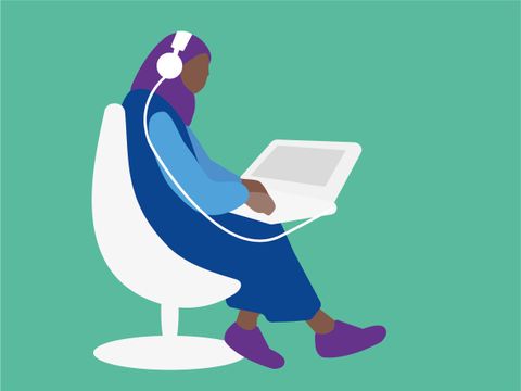 Person mit Kopftuch und Kopfhörern sitzt vor einem Laptop
