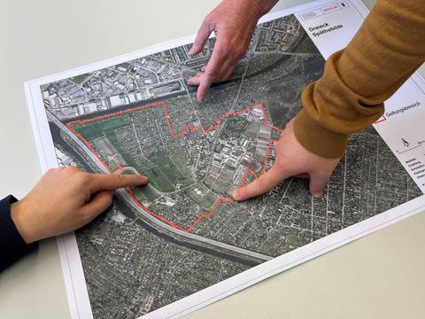 Unterhaltung zum „Dreieck Späthsfelde“; drei Hände zeigen auf den Planausschnitt