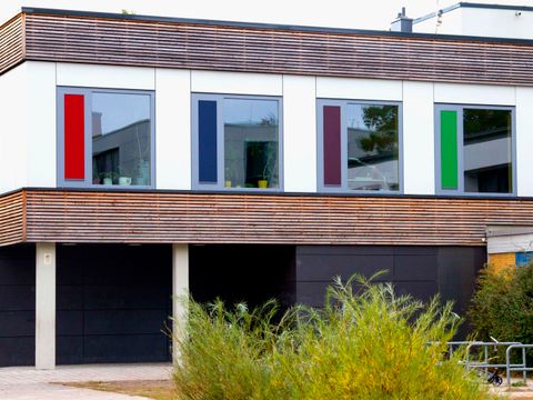Fassade des zweistöckigen Beratungshauses mit farbigen Akzenten