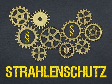 Symbolgrafik mit dem Begriff aus dem Strahlenschutz und Zahnräder auf einer Kreidetafel