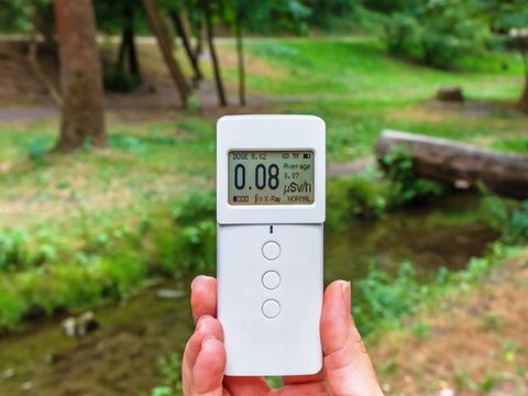 Radiometer-Dosimeter in der Hand im Freien. Messung der ionisierenden Strahlung.