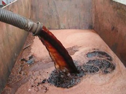 Dunkle Flüssigkeit wird in eine Grube gepumpt