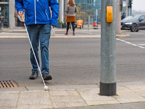 Blinder beim Überqueren der Straße an einer Ampel