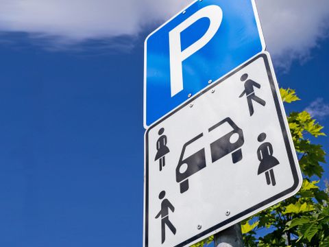 Verkehrsschild: Quadratisches Zusatzschild an Parkplätzen mit vier Personen (zwei männliche und zwei weibliche Piktogramme) und einem durchtrennten Fahrzeug, weist darauf hin, dass dieser Parkplatz Carsharing-Fahrzeugen vorbehalten ist.