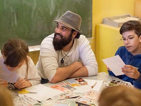 Ein Lehrer und zwei Schulkinder in einem Klassenraum