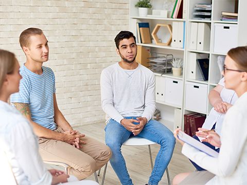 Junge Menschen sitzend in einem Stuhlkreis