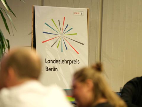 Logo Landeslehrpreis hinter Köpfen