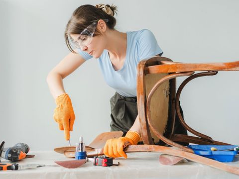 Tischlerin arbeitet an einem Holzstuhl