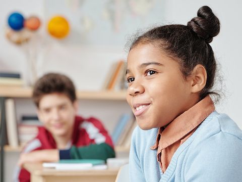lächelnde Schülerin, im Hintergrund ein weiterer Schüler