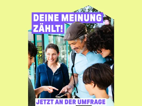 Ein Kind erklärt umstehenden Personen die Umfrage auf dem Handy