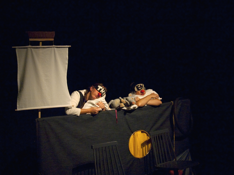 Fotografie einer Theaterszene und schlafenden Darstellenden