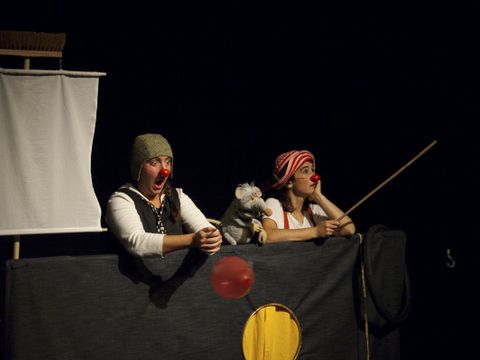 Szenenfoto aus "Brittas Buch" - Zwei Frauen mit Clownsnase und einer Ratte in ihrer MItte sind in einem Boot aus Stoffbahnen