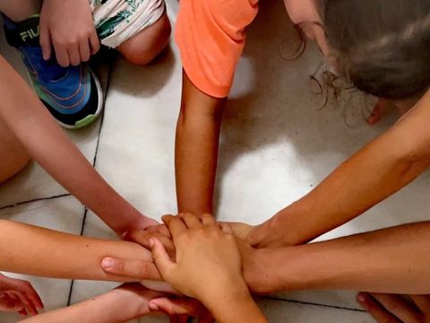 Kinderhände schlagen im Kreis ein