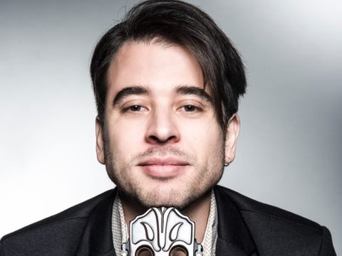 Mann um die 30 posiert mit Gitarre