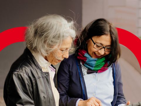 Zwei Frauen schauen gemeinsam auf ein Tablet.