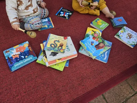 Babys auf Teppech mit vielen Büchern