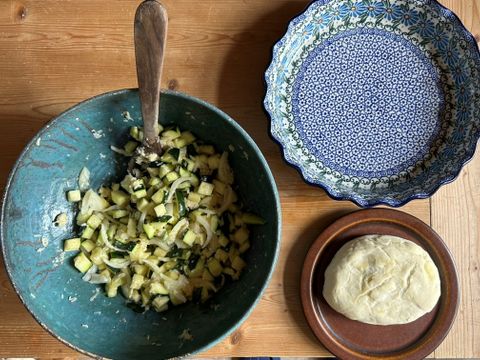 Foto von Keramik-Geschirr mit Gurkensalat und Brötchenteig