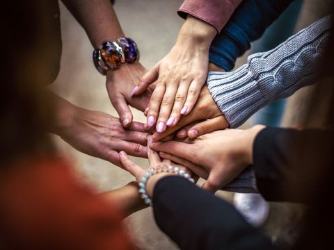 Mehrere Hände schlagen ein im Kreis