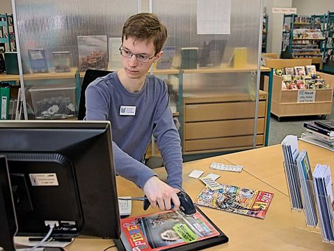 Auszubildender scannt Medien