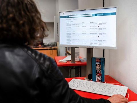 Frau recherchiert am Online-Katalog in der Bibliothek