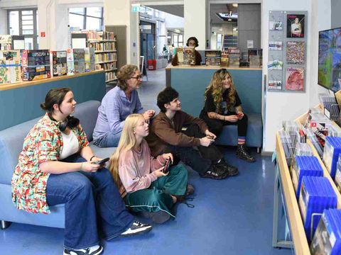 Eine Gruppe von Menschen spielt ein Konsolenspiel zusammen