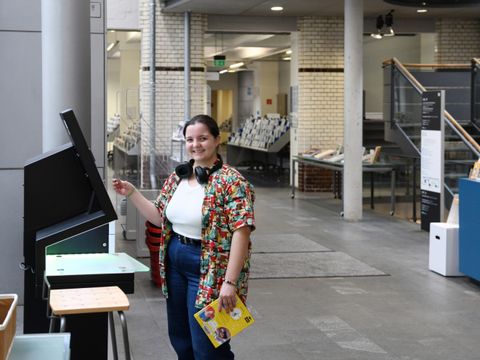 Ein Mädchen leiht ein Buch in der Philipp-Schaeffer-Bibliothek am Automaten aus