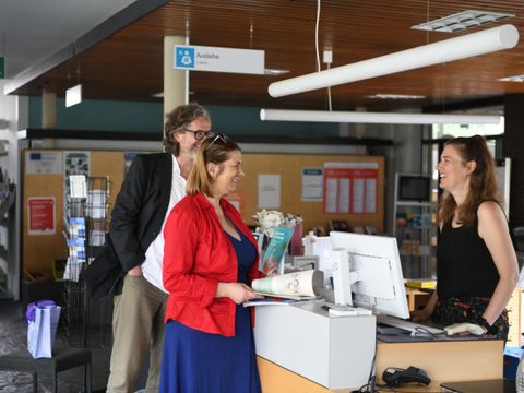 Zwei Nutzende werden an der Theke der Hansabibliothek beraten