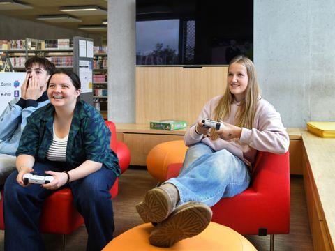Jugendliche spielen zusammen ein Konsolenspiel