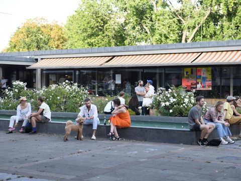 Menschen sitzen vor der Hansabibliothek und tauschen sich aus