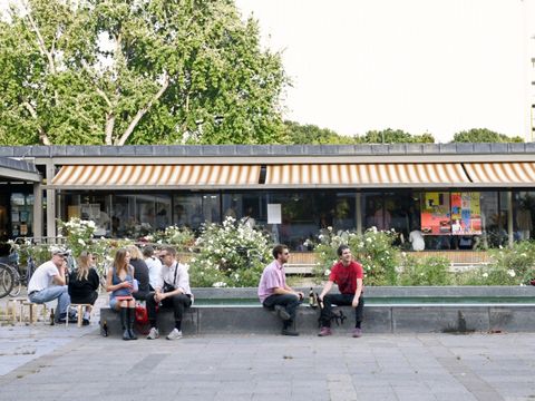 Menschen sitzen vor der Hansabibliothek und tauschen sich aus