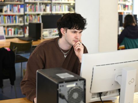 Ein Mann sitzt an einem Computer in der Philipp-Schaeffer-Bibliothek