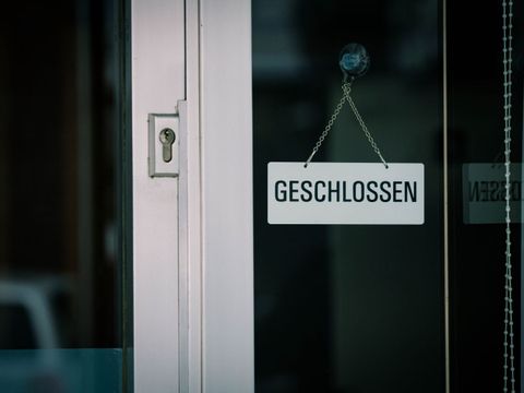 Ein Geschlossen-Schild hängt an einer verglasten Tür