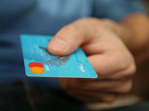 Mann hält Geldkarte zum Bezahlen hin