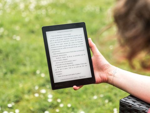 Eine Frau liest auf einem E-Book-Reader ein digitales Buch