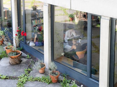 Durch die Scheiben hindurch sieht man Menschen in der Bibliothek am Luisenplatz arbeiten