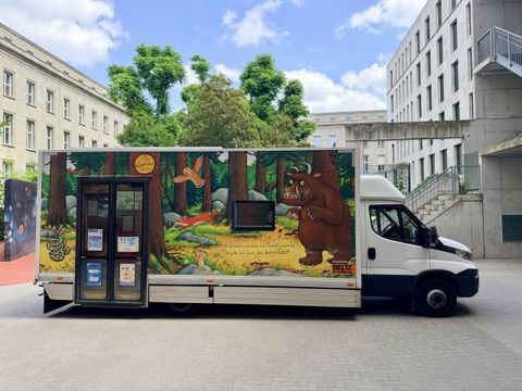 Der Grüffelo-Bücherbus der Stadtbibliothek Berlin-Mitte steht auf einem Schulhof
