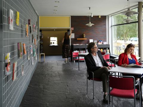 Menschen beim Lesen vor ausstellungswand in der Hansabibliothek