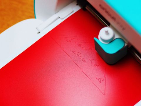Ein Hobbyplotter schneitet ein Motiv aus roter Folie aus
