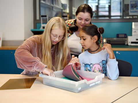 Drei Mädchen im Makerspace schauen sich Material an