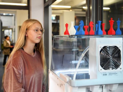 Mädchen steht vor 3D-Drucker