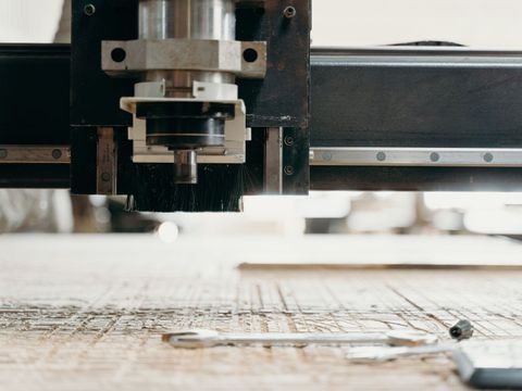 Lasercutter schneidet aus Holzunterlage aus