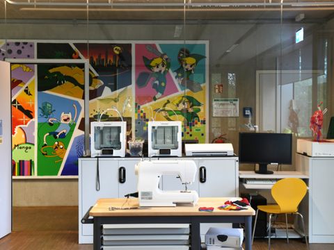 Makerspace in der Schiller-Bibliothek mit 3D-Druckern im Hintergrund und Nähmashcine im Vordergrund